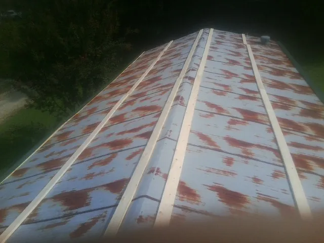 Rusted metal roof panels with new wood purlins before replacement — Storm Damage Roof Repair in Plummer by Roofing Brothers
